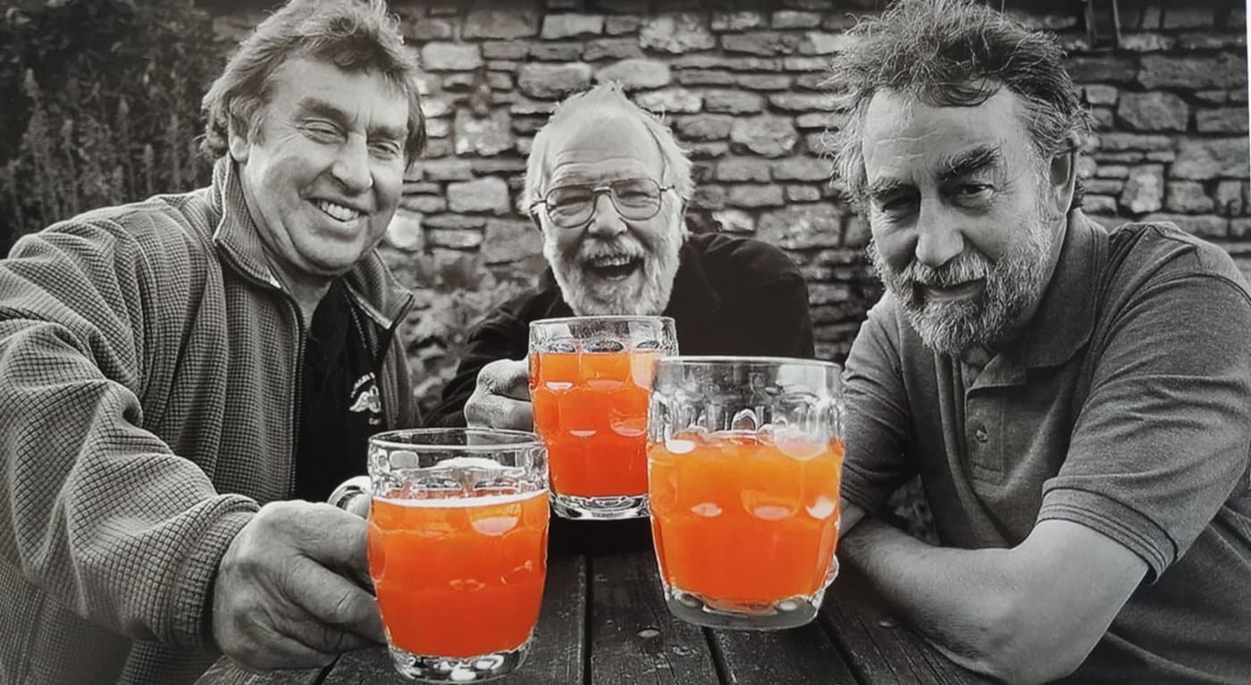 Three regulars raising glasses of cider