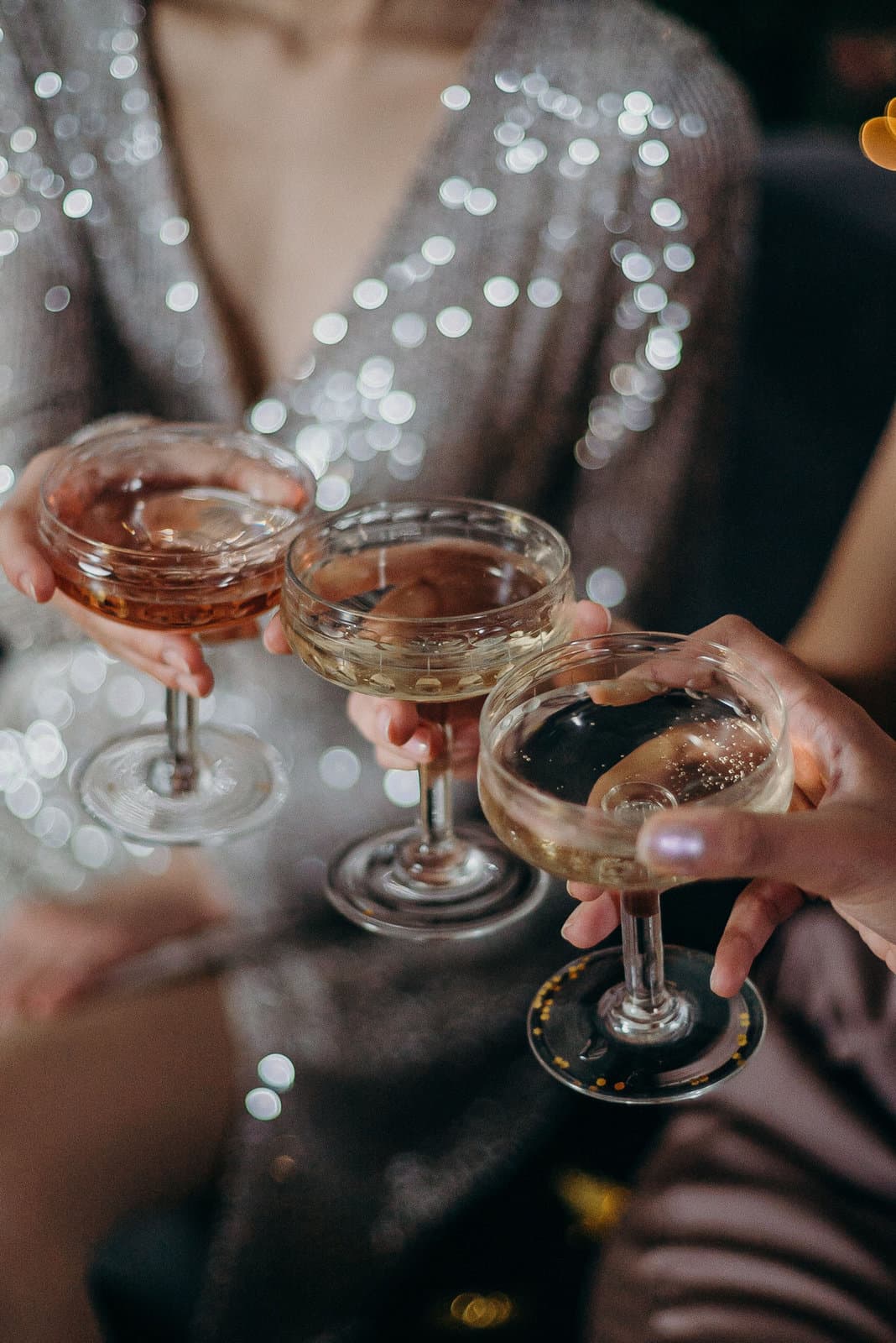 Friends clinking coupe glasses of cocktails